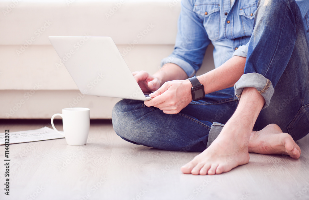 Fototapeta premium Man sitting on floor and using laptop