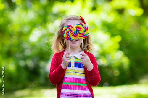 Little girl with colorful candy lollipop