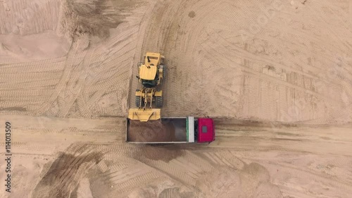 Aerial view of bulldozer pouring sand into truck