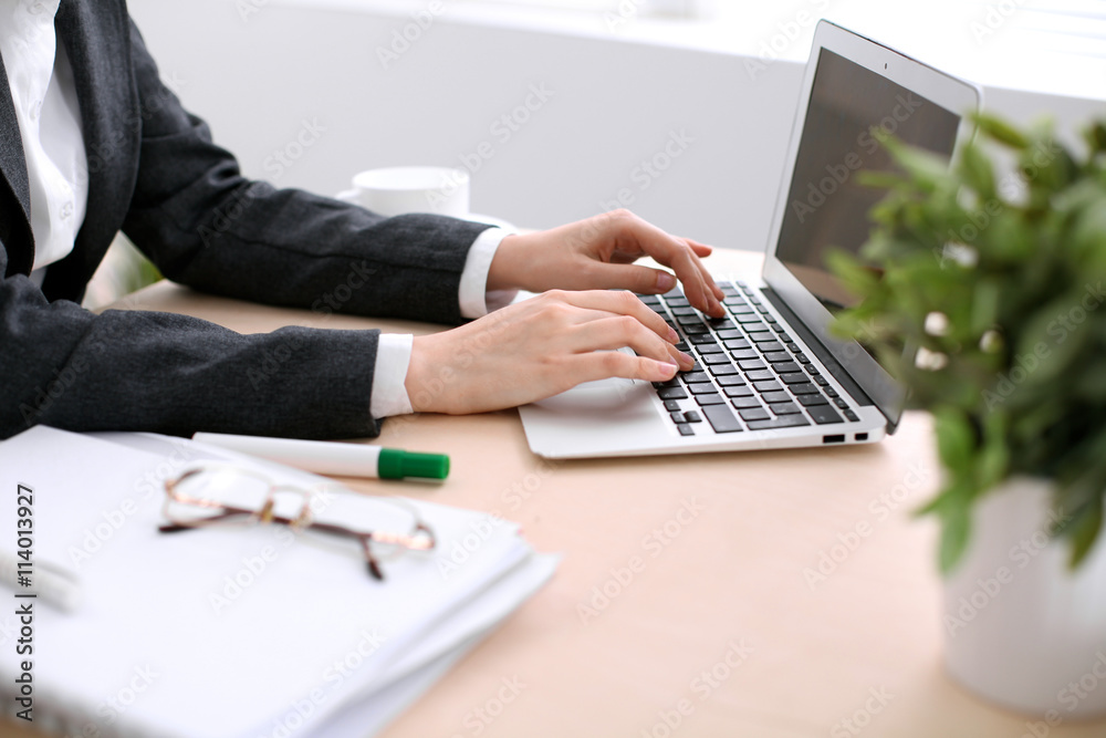 Close up of business woman hands typing on laptop computer in the white colored office. Close up of business woman hands typing on laptop computer in the white colored office.