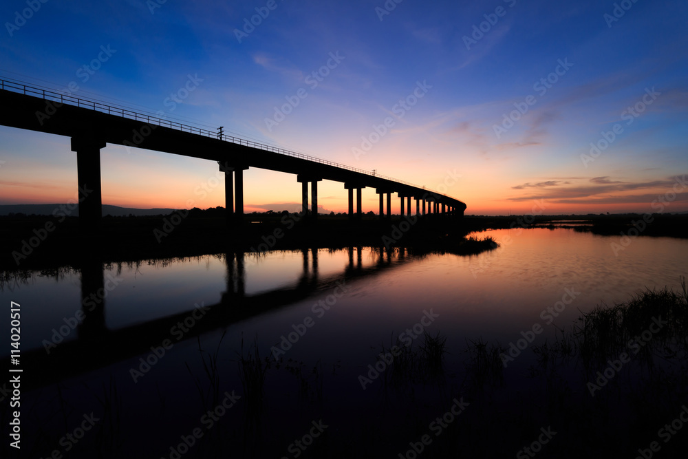 train bridge over the dam at sunset in Thailand