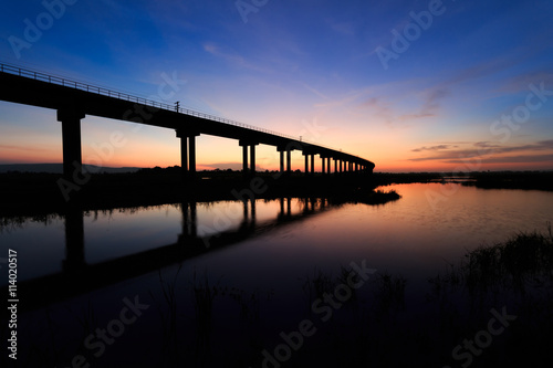 train bridge over the dam at sunset in Thailand