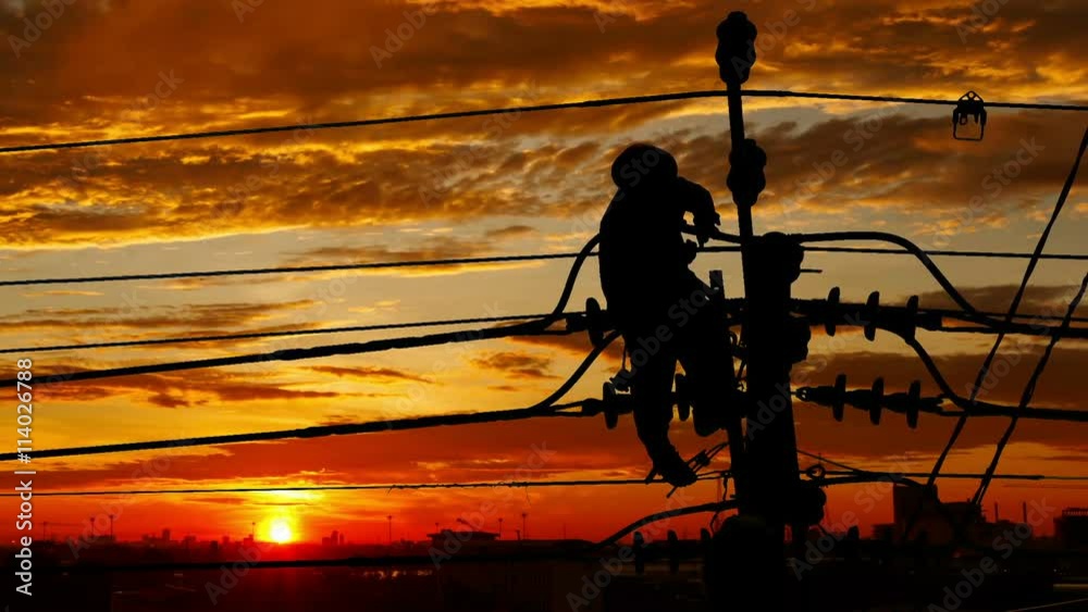 Silhouette of an electrician climbing a newly installed utility pole with clouds time lapse
