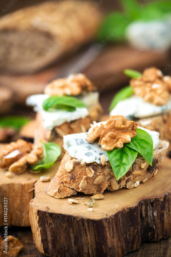 Roquefort and walnut canape decorated with leaves of fresh basil Roquefort and walnut canape decorated with leaves of fresh basil