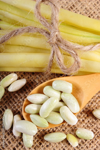 Seeds and stack of yellow beans on jute canvas, healthy food