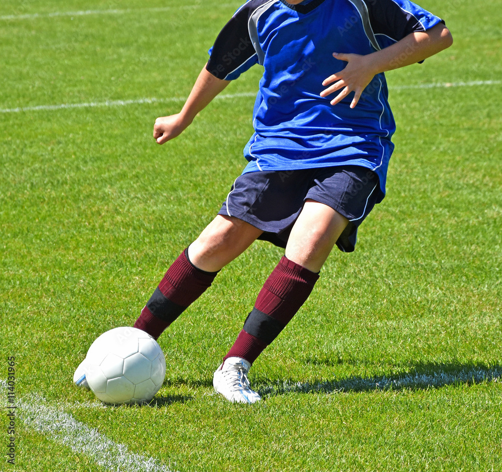 Young child kicks the ball