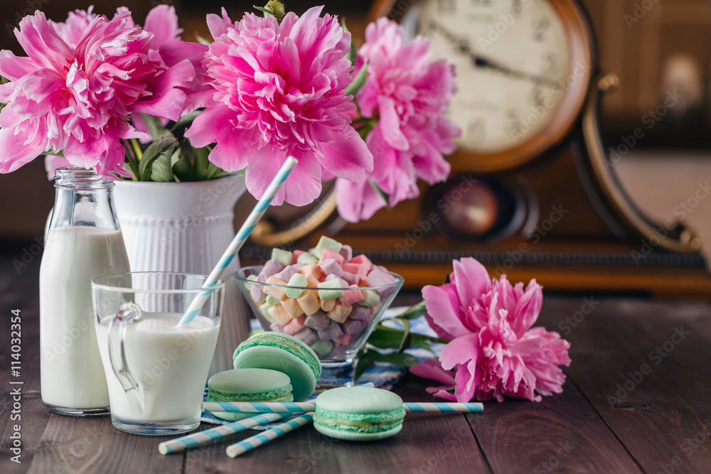 Kid breakfast with milk and macaroons on table with flowers Kid breakfast with milk and macaroons on table with flowers