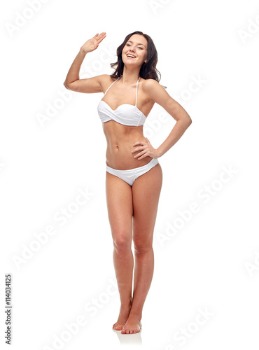 happy young woman in white swimsuit waving hand