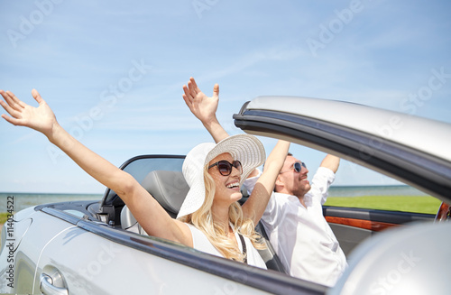 happy man and woman driving in cabriolet car