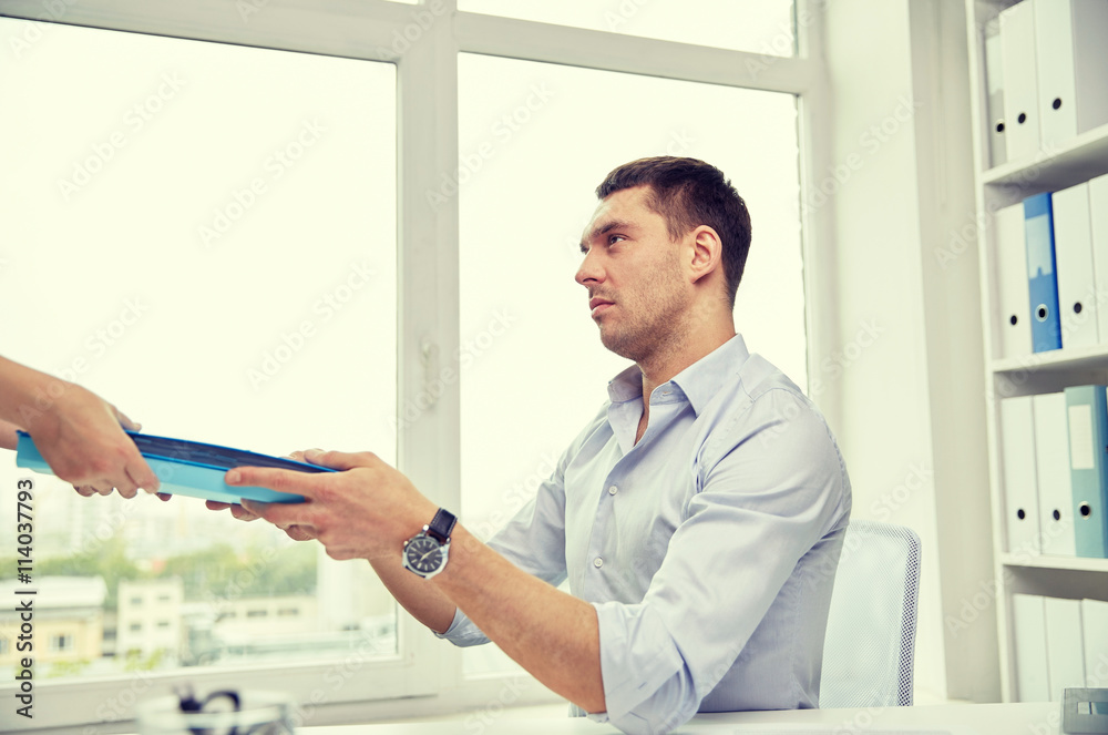 businessman taking papers from secretary in office businessman taking papers from secretary in office