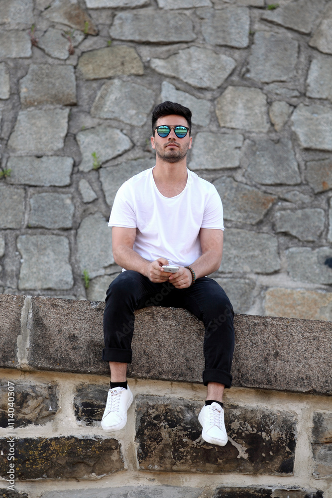 Fototapeta premium Handsome young man with mobile phone on the street