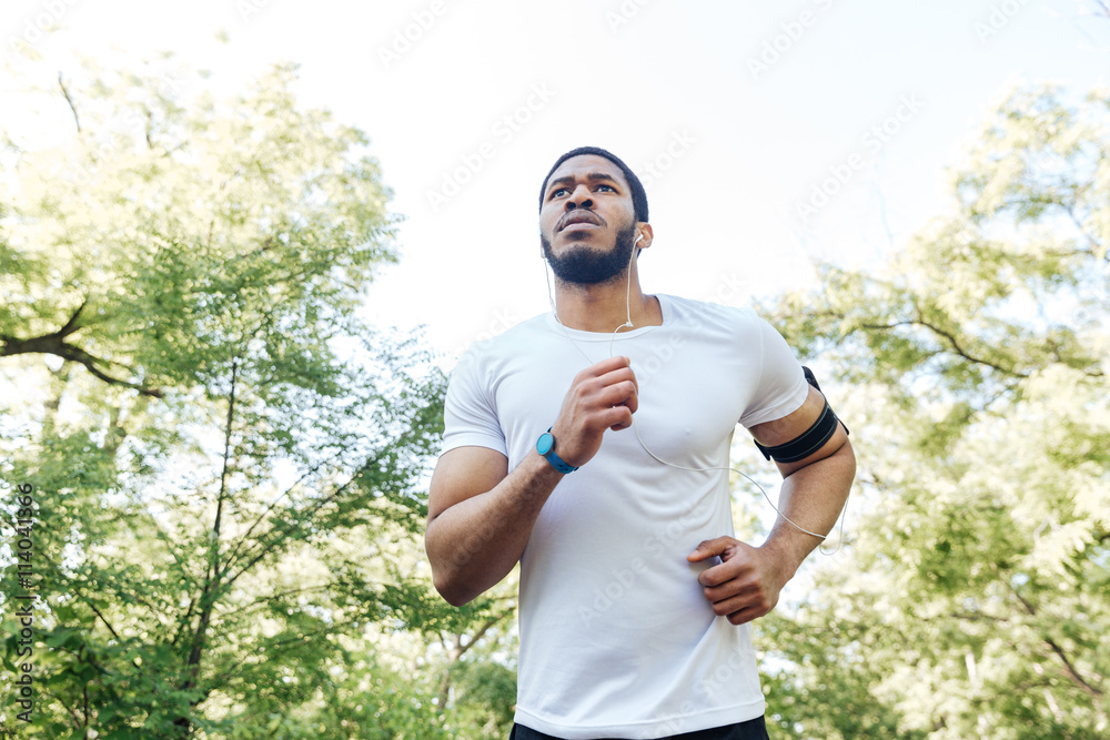 Focused african sportsman running outdoors Focused african sportsman running outdoors