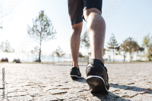 Legs of male sportsman running in the city