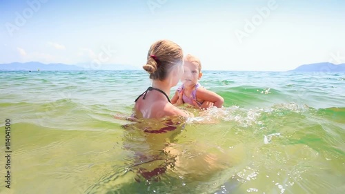 Mother Tosses High up Little Daughter in Azure Sea