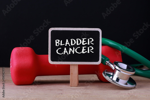 Medical concept - Stethoscope and dumbbell on wood with Bladder Cancer word photo