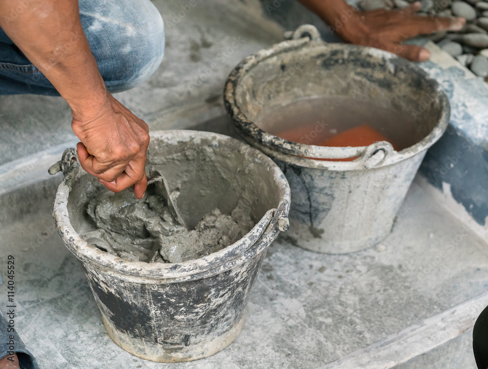 cement portland gray fresh mortar mix with spatula tool in bucket
