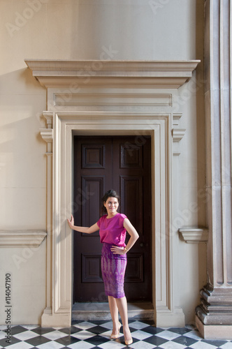 Woman in Thai silk traditional dress stand in old classic building