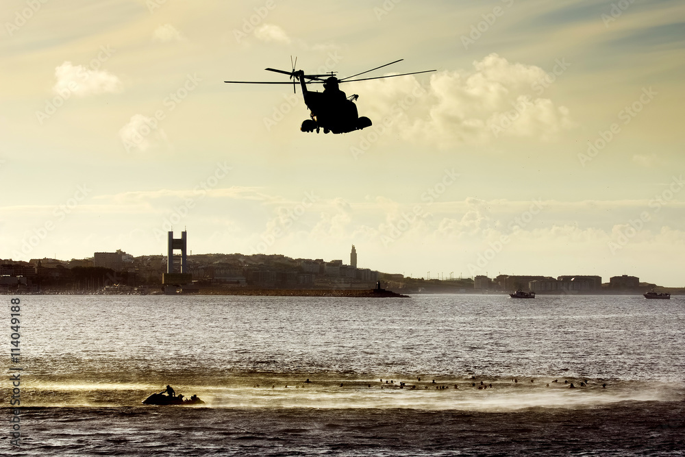 rescue helicopter silhouette in atlantic ocean in rescue training at sunset rescue helicopter silhouette in atlantic ocean in rescue training at sunset
