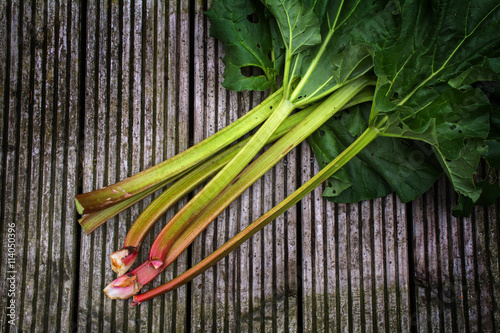 organic rhubarb stalks with leaves on rustic woo  view from above
