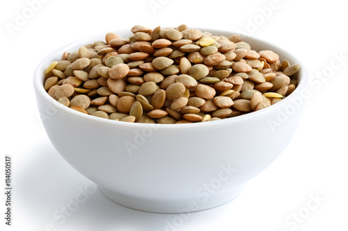 White ceramic bowl of green uncooked lentils isolated on white i photo
