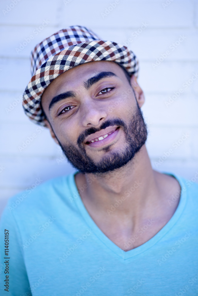 Retrato oblicuo de joven mulato sobre fondo de ladrillos blancos Stock