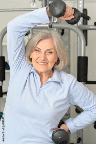 Fototapeta Naklejka Na Ścianę i Meble -  Elderly woman exercising in gym