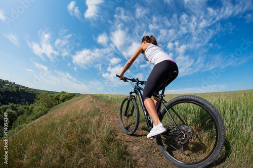 Mountain biking happy sportive girl relax in meadows sunny countryside