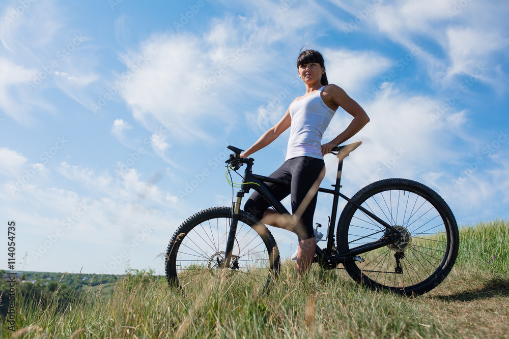 Mountain biking happy sportive girl relax in meadows sunny countryside