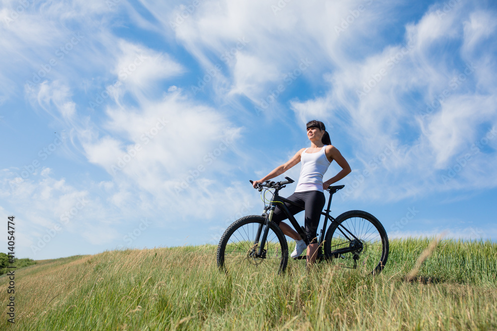 Mountain biking happy sportive girl relax in meadows sunny countryside