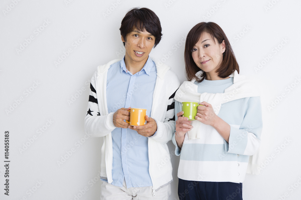 マグカップを持って立つ夫婦 マグカップを持って立つ夫婦