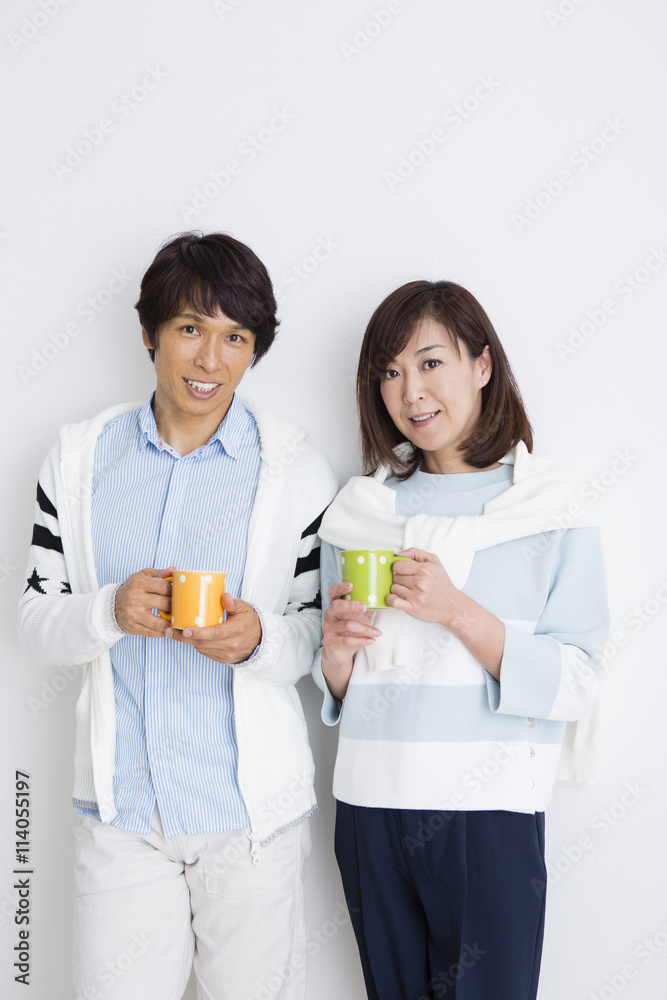マグカップを持って立つ夫婦