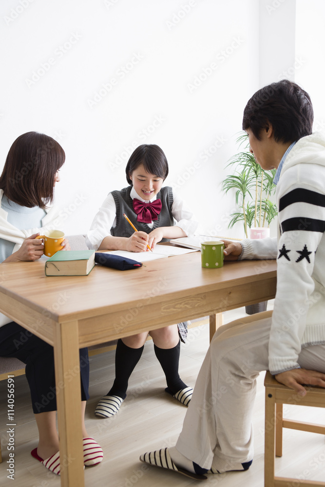 娘の勉強を見る両親 娘の勉強を見る両親