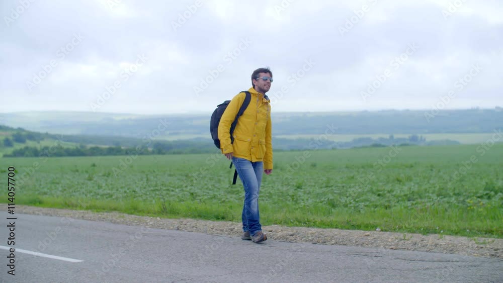 man hitchhiking in the countryside, on an empty road without cars man hitchhiking in the countryside, on an empty road without cars