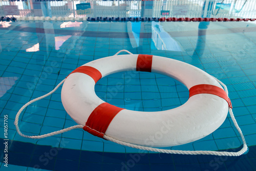 A red and white lifebuoy (Kisby Ring) floating in a covered swimming pool in Nahariya