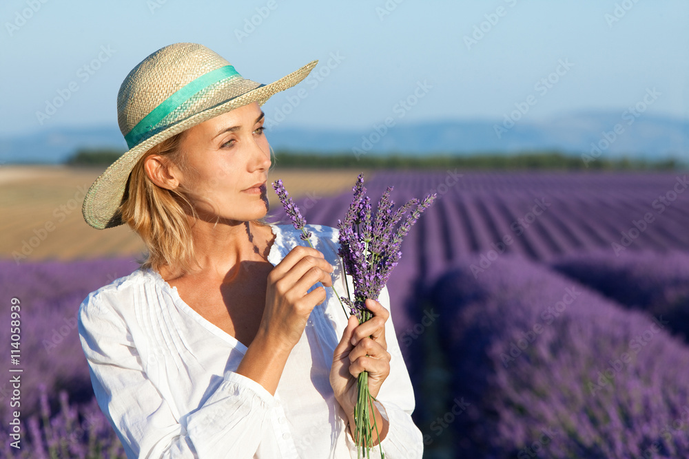 Naklejka premium femme dans des champs de lavande avec un bouquet