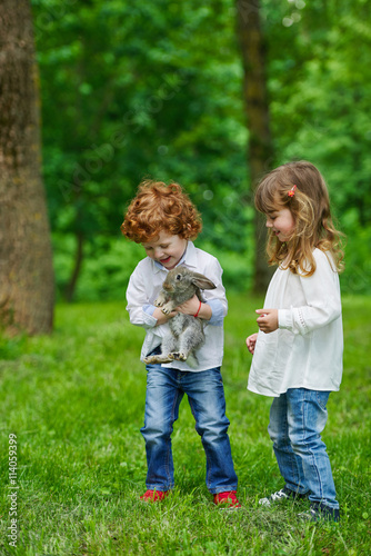 boy and girl playing with rabbit