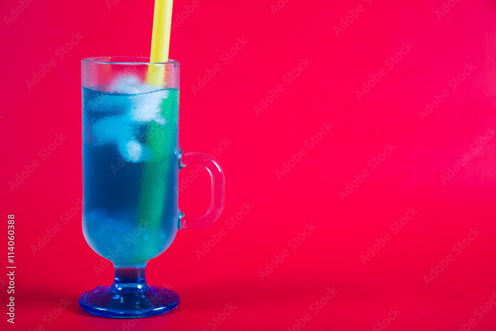 Refreshing blue cocktail on a red background Refreshing blue cocktail on a red background