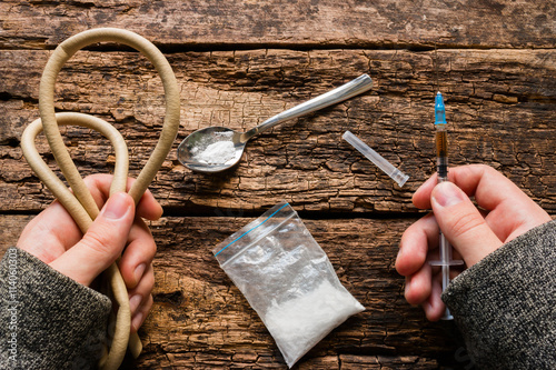 drug addict holding syringe and tourniquet