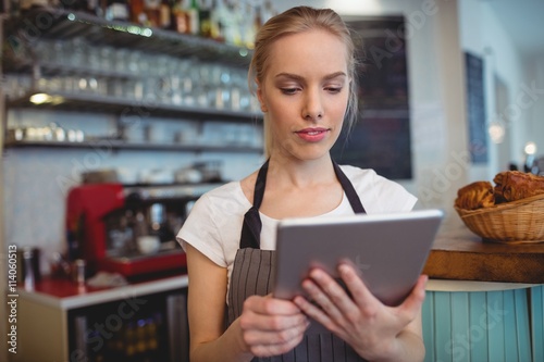 Female owner using tablet at cafe