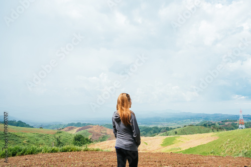 Asian girl look at each side in mountainous scenery.