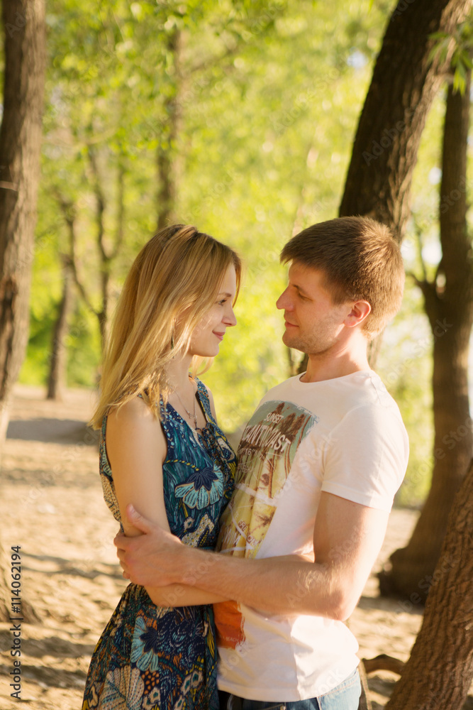 the young loving couple embraces outdoors in summer day
the young loving couple embraces outdoors in summer day