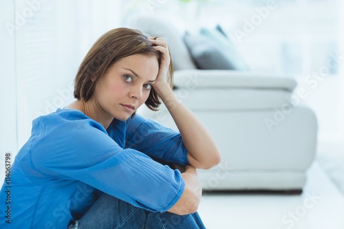 Portrait of sad woman by sofa