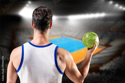 Composite image of rear view of male athlete holding ball