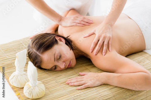 Naked woman receiving massage from masseur