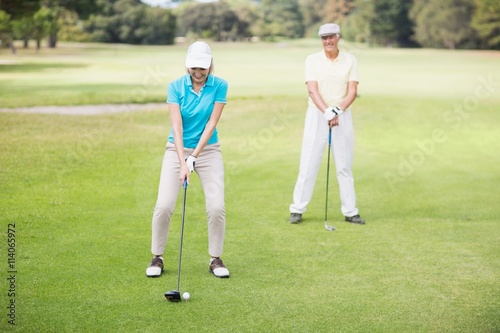 Smiling mature couple playing golf 