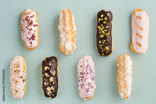 Eclairs with chocolate ganache and icing with different toppings