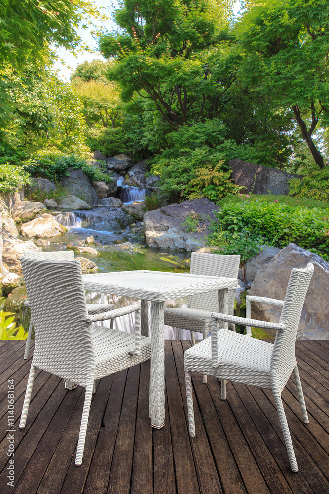 Obraz premium White dining table on wooden floor and waterfall background