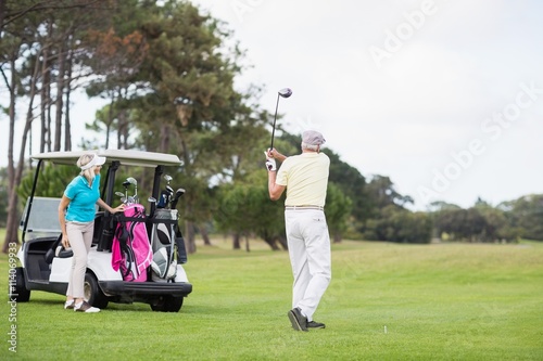 Full length of man taking shot at golf course