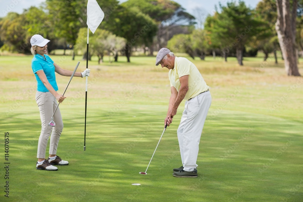 Fototapeta premium Mature man and woman playing golf