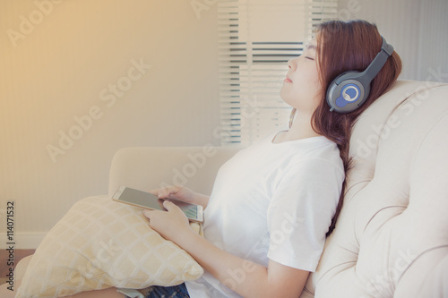asian young Woman with headphones and tablet on sofa